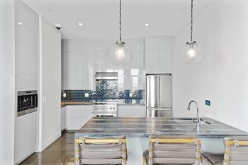 A modern kitchen with a large island and stainless steel appliances.